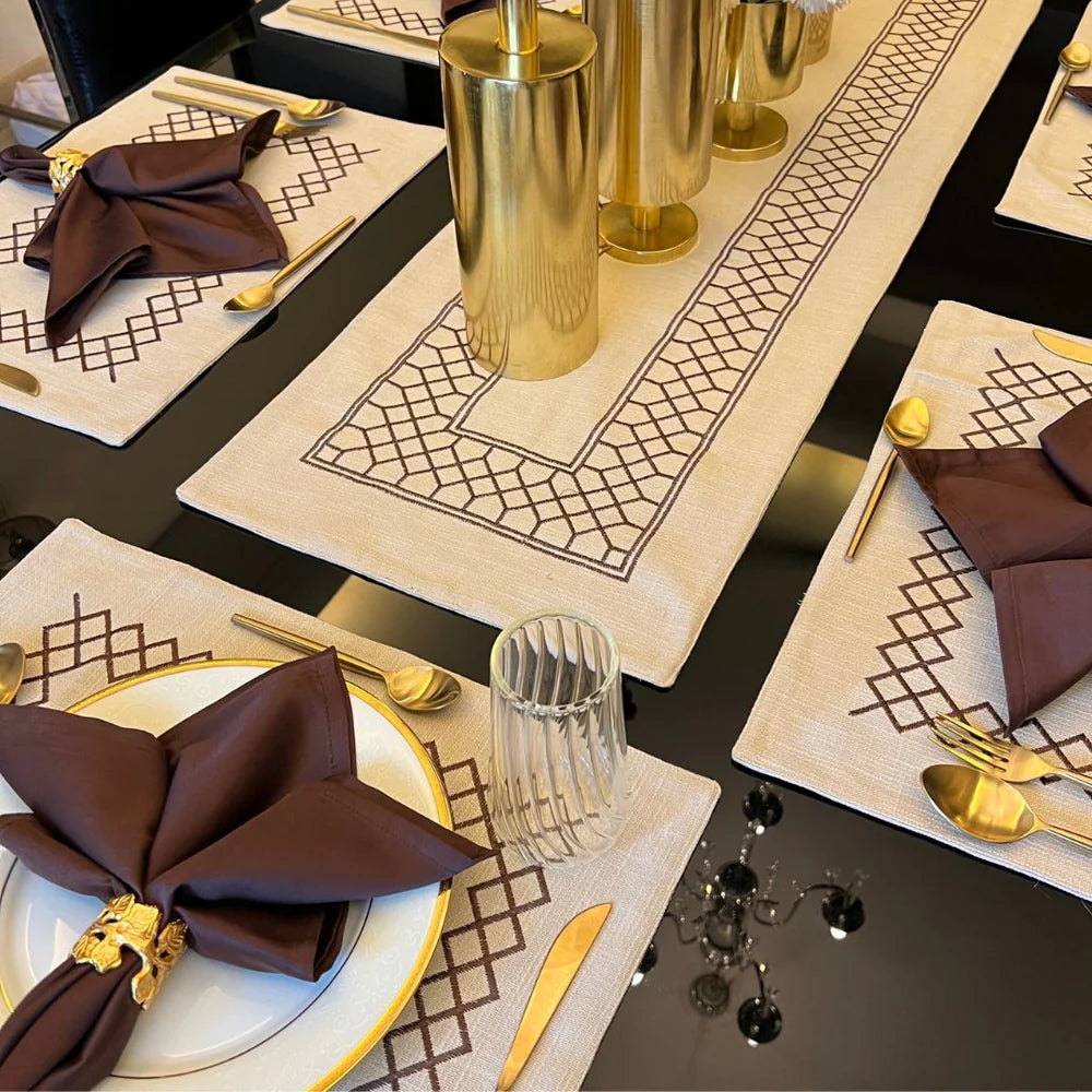 Beige table linen set with zigzag pattern and brown napkins on a dining table.
