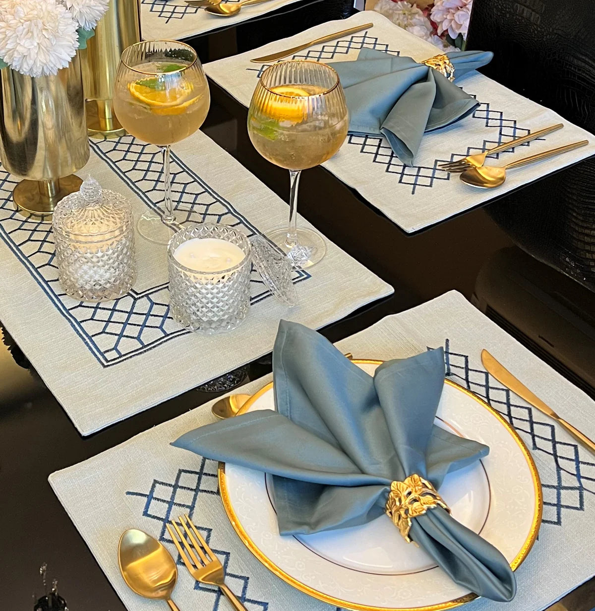 Sage green table linen set with zigzag pattern and gold cutlery.